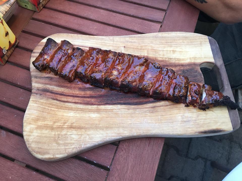Ganzer Strang Spare Ribs, aufgeschnitten auf einem Holzbrett