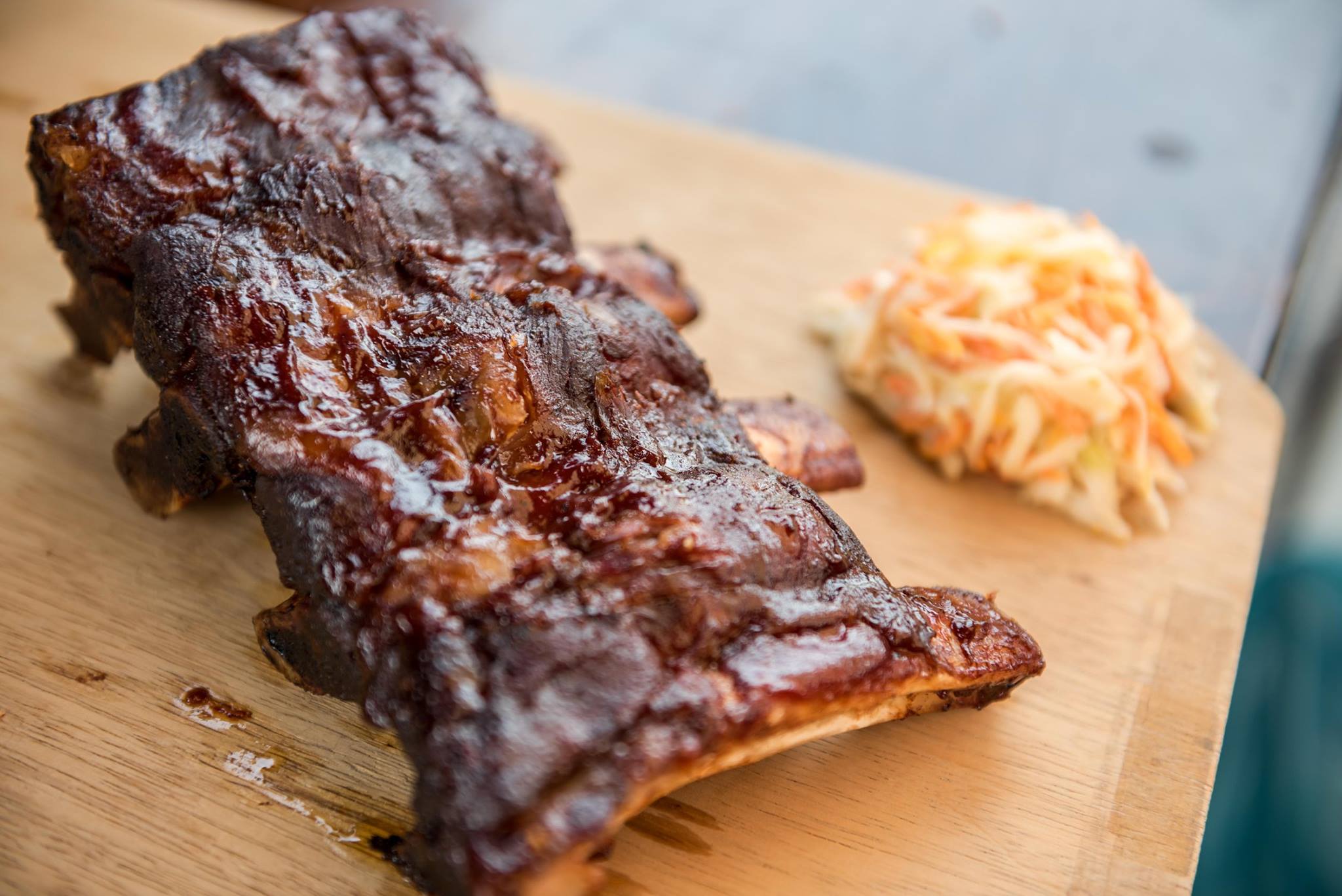 Glasierte Spare Ribs mit Coleslaw auf einem Holzbrett
