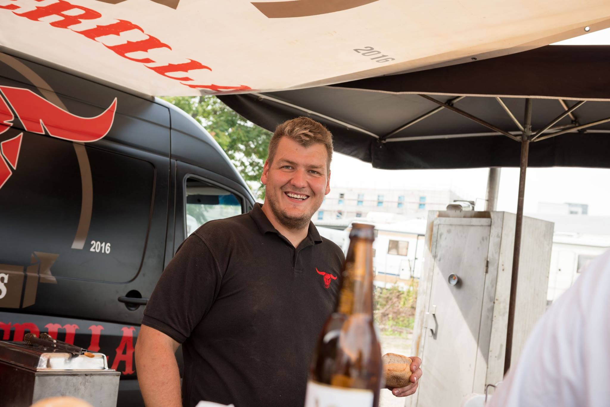 Inhaber Helmuth lacht am BBQ-Stand von Texas Smoke Guerilla